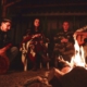 Eine Menschen sitzen während der Ayahuasca Zeremonie gemeinsam am Feuer und musizieren zusammen